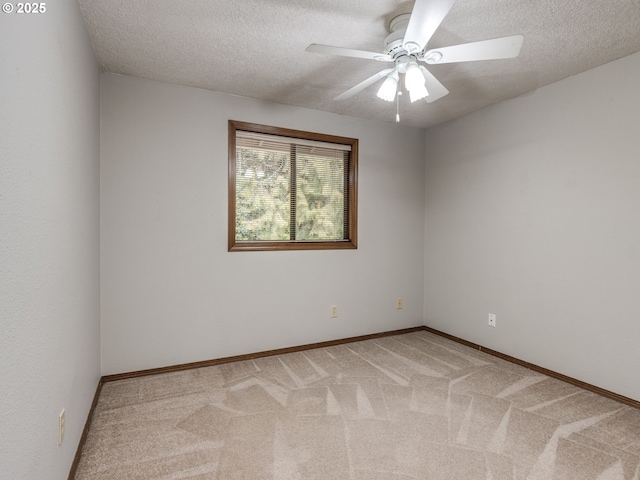 carpeted spare room featuring ceiling fan and a textured ceiling