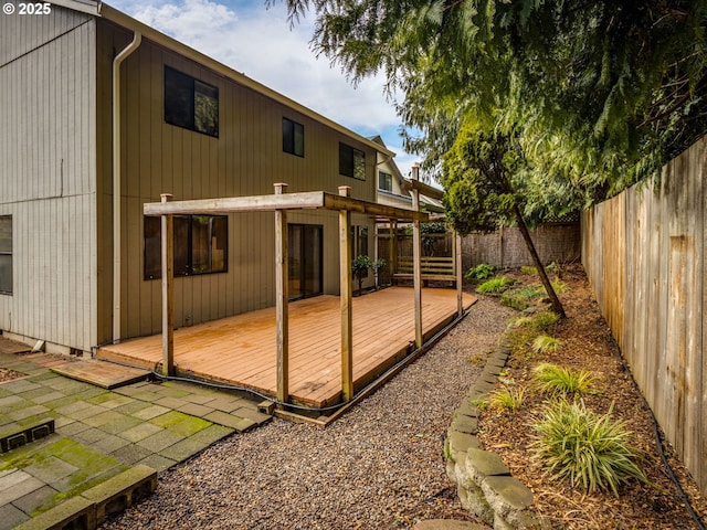 back of property with a wooden deck and a patio area