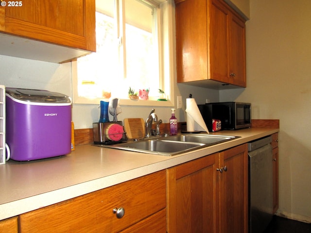 kitchen featuring a sink, brown cabinetry, light countertops, and stainless steel dishwasher