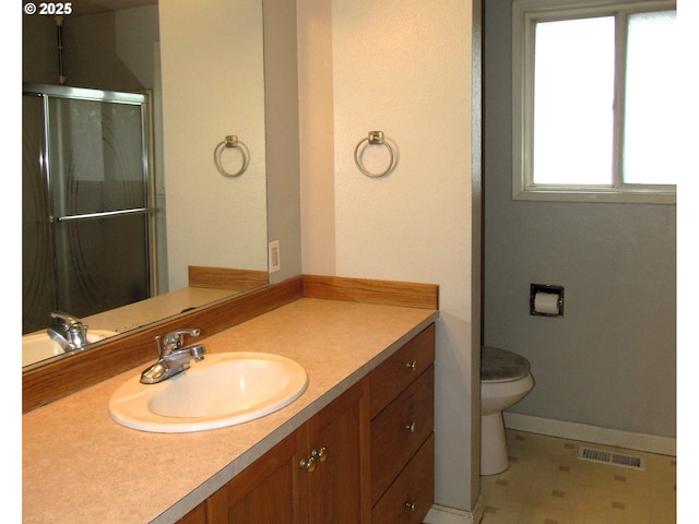 full bathroom with a shower with door, visible vents, toilet, vanity, and baseboards