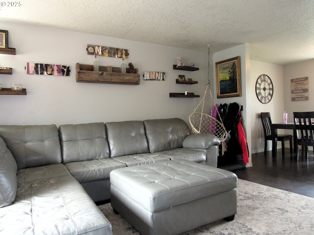 living area with a textured ceiling and dark wood-type flooring