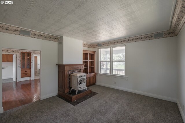 38588 Goar Rd, Scio, OR 97374 - unfurnished living room featuring a wood stove, carpet floors, baseboards, and an ornate ceiling