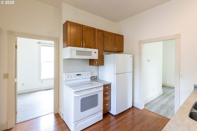 215 W 9th St, The Dalles, OR 97058 - kitchen featuring white appliances, brown cabinets, wood finished floors, and light countertops