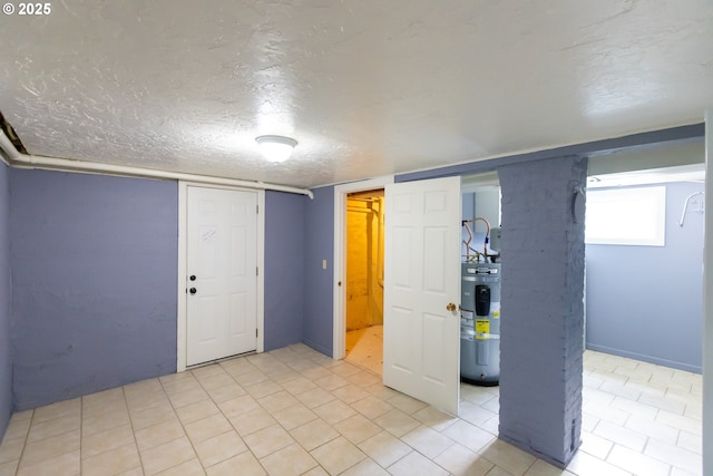 215 W 9th St, The Dalles, OR 97058 - below grade area with electric water heater, a textured ceiling, and light tile patterned floors