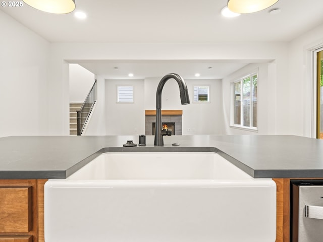 details featuring a sink, dark countertops, a fireplace, and recessed lighting