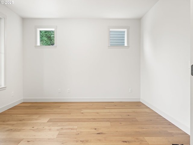 unfurnished room featuring baseboards and wood-type flooring
