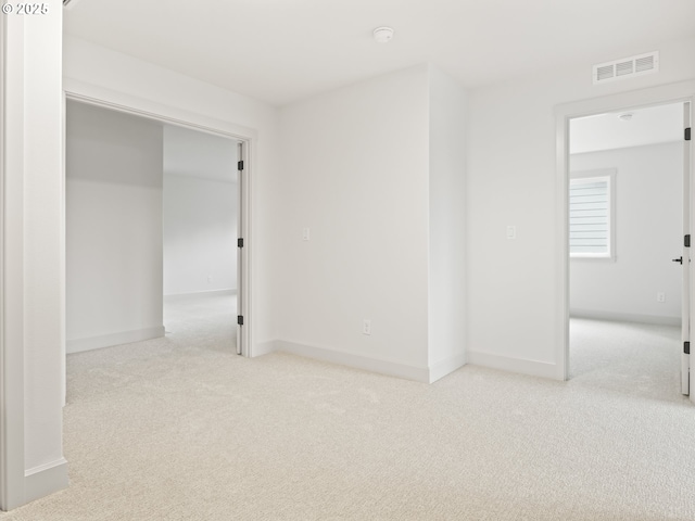 carpeted empty room featuring visible vents and baseboards