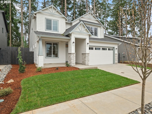 craftsman-style house with stone siding, a front yard, driveway, and fence