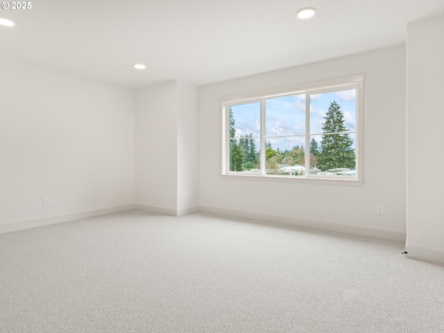 carpeted spare room featuring recessed lighting and baseboards