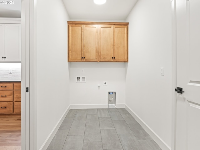 laundry room with baseboards, hookup for an electric dryer, cabinet space, washer hookup, and hookup for a gas dryer