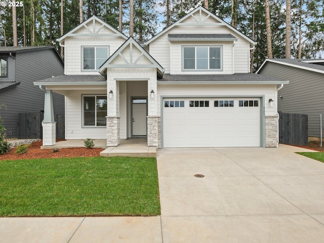 craftsman inspired home with driveway, an attached garage, a shingled roof, a front lawn, and stone siding