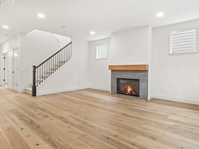 unfurnished living room featuring stairway, light wood-style flooring, and recessed lighting