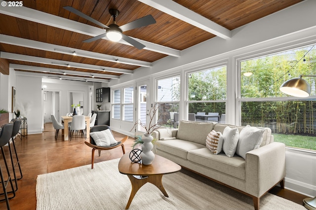 living room featuring beamed ceiling, wood ceiling, baseboards, and ceiling fan