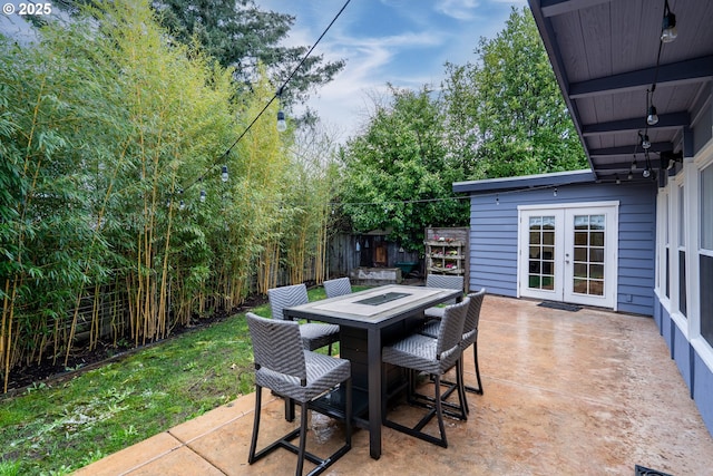 view of patio / terrace with outdoor dining space, french doors, fence, and a fire pit