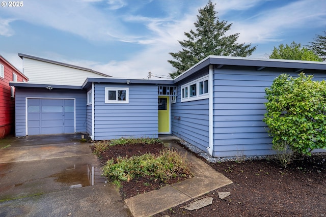 mid-century inspired home featuring concrete driveway and an attached garage