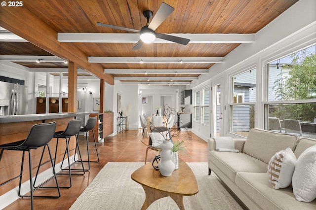 living area with beamed ceiling, ceiling fan, and wooden ceiling