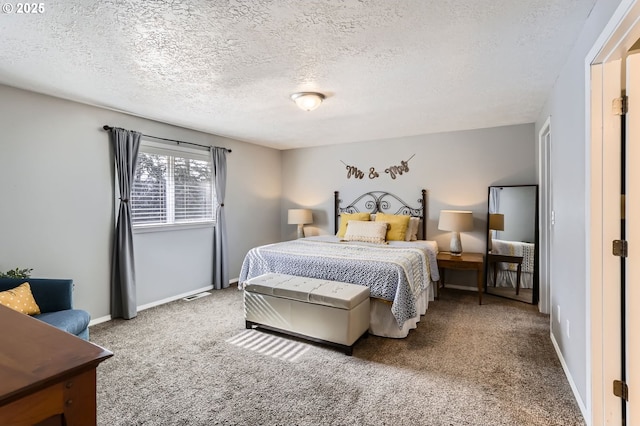 carpeted bedroom featuring visible vents, baseboards, and a textured ceiling