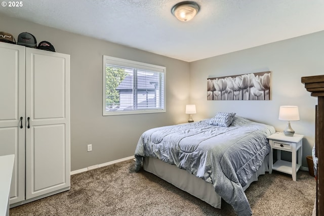 bedroom with carpet, a textured ceiling, and baseboards