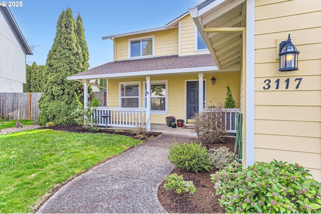 exterior space with a front lawn, fence, a porch, and roof with shingles