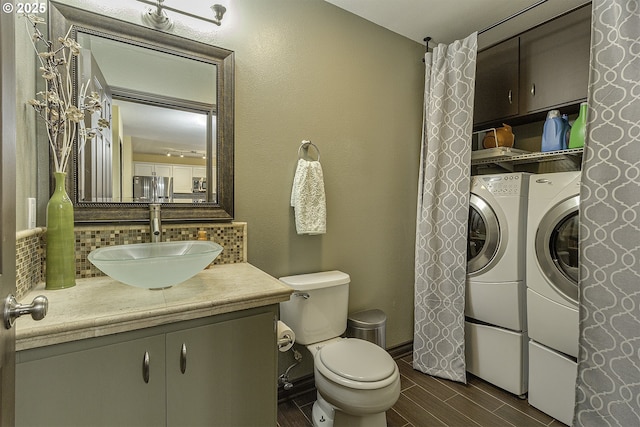 4422 SW Appletree Pl, Beaverton, OR 97078 - bathroom with washer and clothes dryer, wood finished floors, vanity, and decorative backsplash