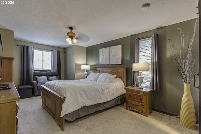 4422 SW Appletree Pl, Beaverton, OR 97078 - bedroom featuring light carpet, multiple windows, a ceiling fan, and a textured ceiling