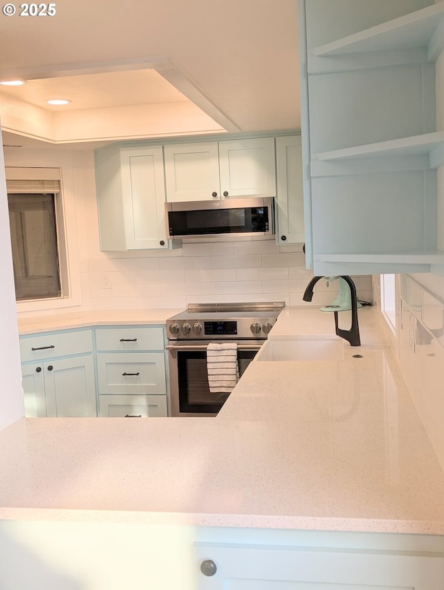620 Wimbledon Ct, Eugene, OR 97401 - kitchen with appliances with stainless steel finishes, tasteful backsplash, light stone counters, a tray ceiling, and recessed lighting
