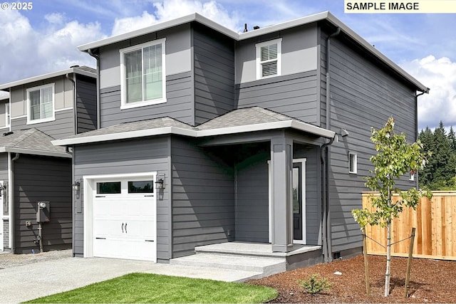 view of front facade with an attached garage, fence, and roof with shingles