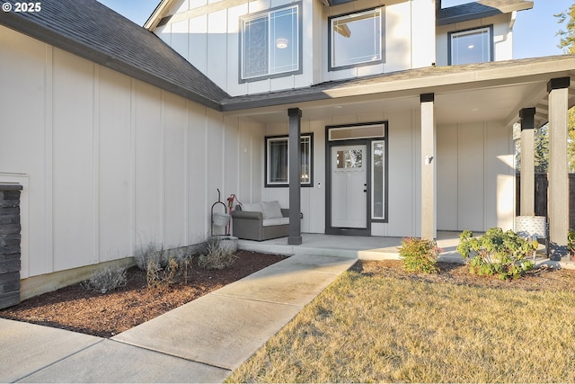 entrance to property featuring a porch, a yard, and elevator