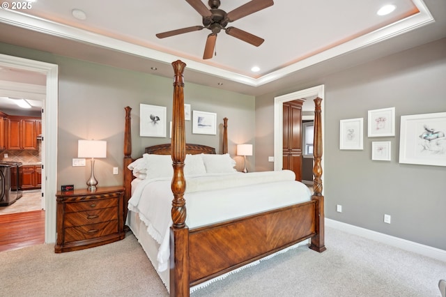 bedroom with ceiling fan, a tray ceiling, baseboards, recessed lighting, and light carpet