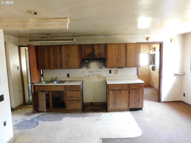 431 NE Alder St, Yachats, OR 97498 - kitchen with a sink, brown cabinets, and light countertops
