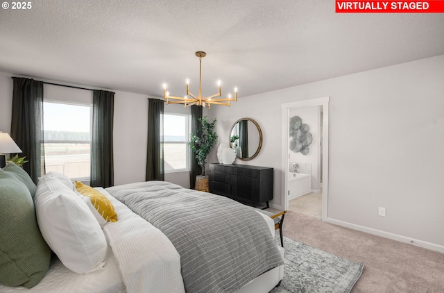 bedroom with a notable chandelier, light colored carpet, a textured ceiling, and ensuite bathroom