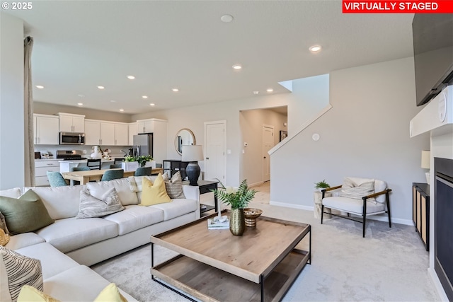 living area with recessed lighting, light colored carpet, and baseboards