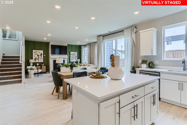 kitchen featuring a kitchen island, a wealth of natural light, and white cabinets