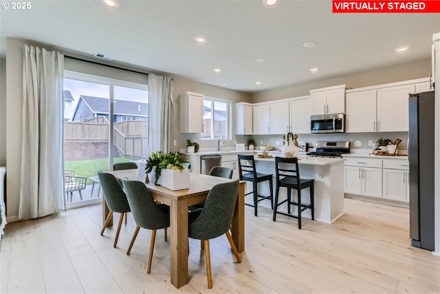 dining room with sink and light hardwood / wood-style floors