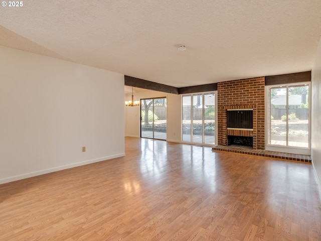 20270 SW Brightwood Ct, Beaverton, OR 97003 - unfurnished living room with a chandelier, wood finished floors, plenty of natural light, baseboards, and a textured ceiling