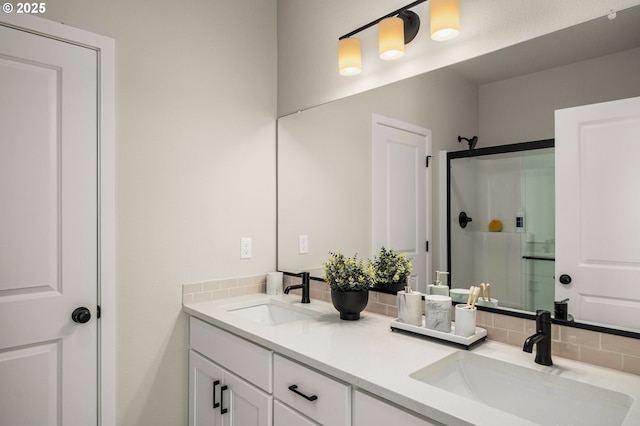 bathroom with double vanity, a sink, backsplash, and a shower stall
