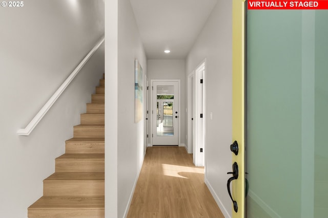 interior space featuring recessed lighting, baseboards, stairs, and wood finished floors