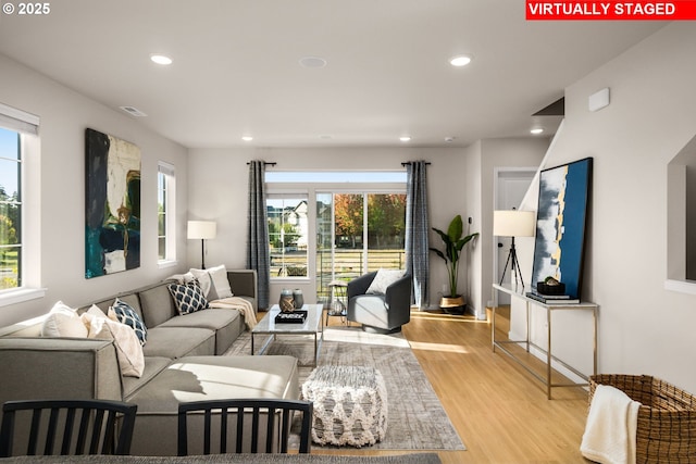 living area with light wood-style floors, recessed lighting, and a healthy amount of sunlight