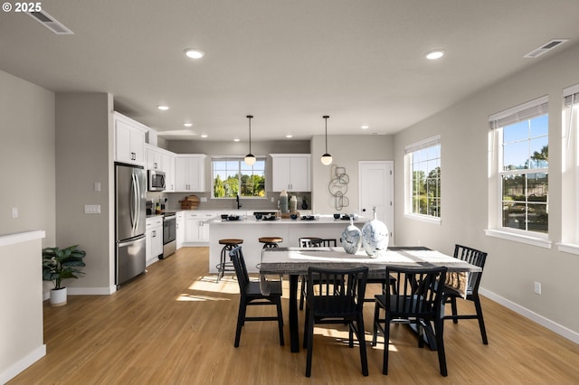 dining space featuring recessed lighting, visible vents, and light wood-style flooring