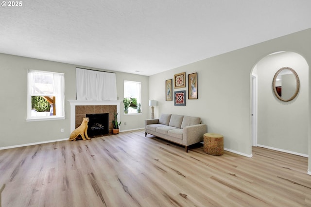 4908 Holly St, Springfield, OR 97478 - living area featuring wood finished floors, arched walkways, and a tile fireplace