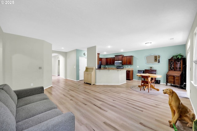 4908 Holly St, Springfield, OR 97478 - living room featuring arched walkways, light wood-style flooring, and recessed lighting