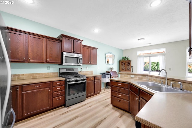 4908 Holly St, Springfield, OR 97478 - kitchen with stainless steel appliances, light wood-style floors, recessed lighting, light countertops, and tasteful backsplash