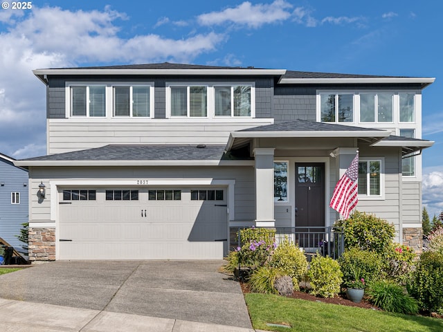 prairie-style house with concrete driveway, a shingled roof, stone siding, and a garage
