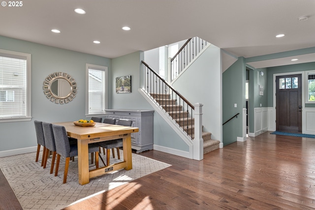 dining area featuring stairs, wood finished floors, baseboards, recessed lighting, and a wainscoted wall