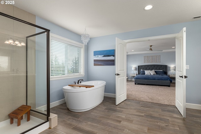 bathroom featuring a freestanding tub, a stall shower, wood finished floors, and connected bathroom