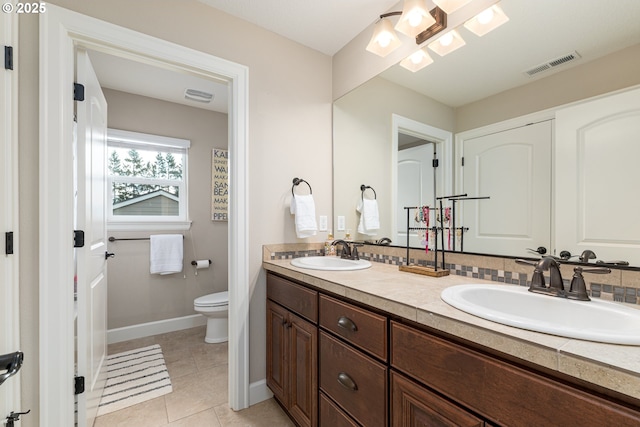 full bathroom with double vanity, toilet, visible vents, and a sink
