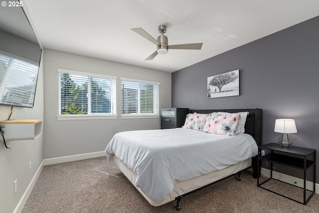 bedroom featuring carpet floors, multiple windows, baseboards, and a ceiling fan