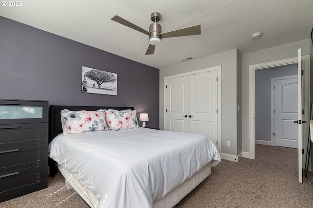 carpeted bedroom with a textured ceiling, a ceiling fan, baseboards, visible vents, and a closet