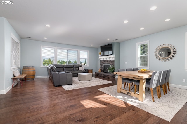 dining room with baseboards, a fireplace, recessed lighting, and wood finished floors