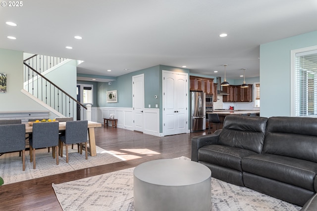 living room with stairs, recessed lighting, wainscoting, and dark wood-type flooring